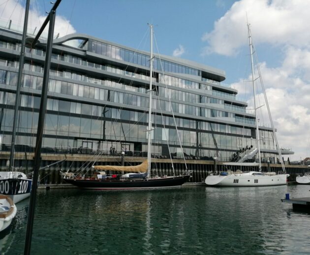 white and brown boat on sea near white concrete building during daytime