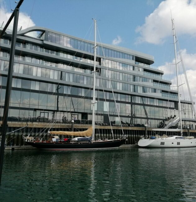 white and brown boat on sea near white concrete building during daytime