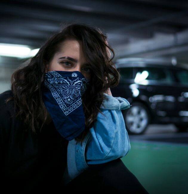 woman sitting on parking area pavement