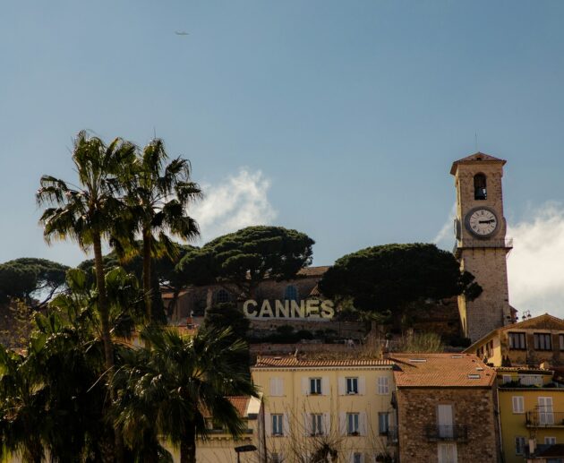 a clock tower on top of a building next to palm trees