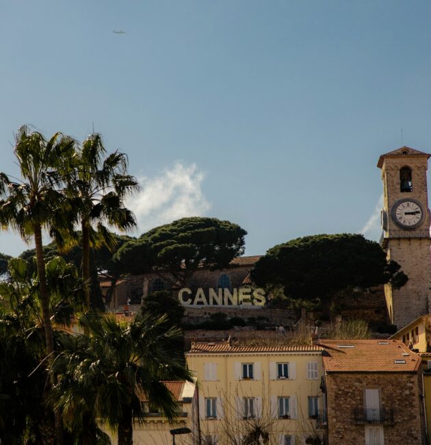 a clock tower on top of a building next to palm trees