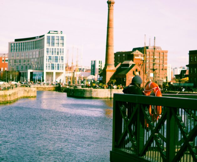 a couple of people standing on a bridge over a river