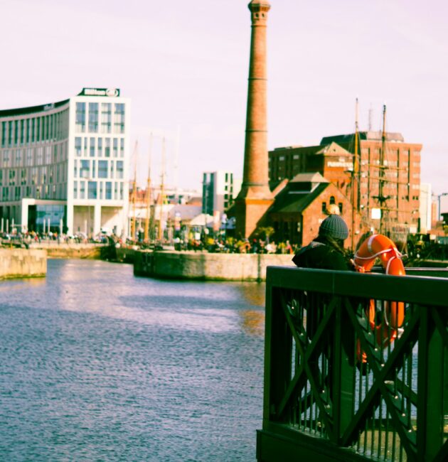 a couple of people standing on a bridge over a river